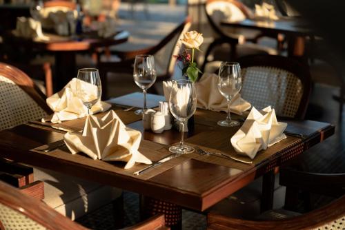a table in a restaurant with wine glasses and napkins at Edensee Kega Beach Resort in Ke Ga