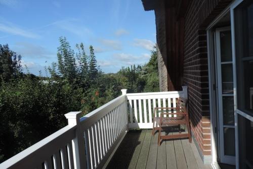 a wooden porch with a bench on the side of a house at "Koppeldeich" in Dierhagen