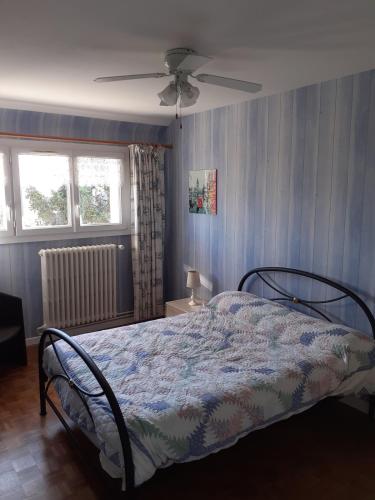 une chambre avec un lit et un ventilateur de plafond dans l'établissement Villa Beauregard La Roche Posay, à La Roche-Posay