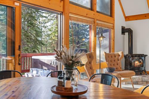 a dining room with a table and chairs and windows at Remodeled 4BDR Cabin with AC Lake Views Hot-Tub Bunk Room Excellent Location in Kings Beach