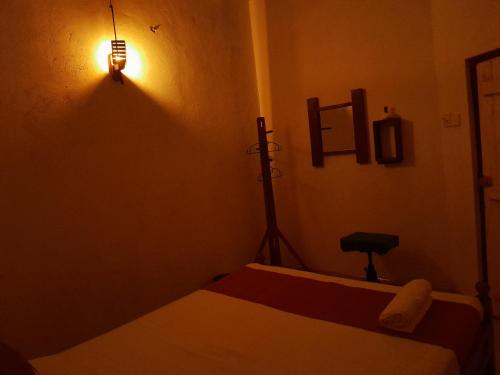 a bedroom with two beds and a light on the wall at Lime House in Udawalawe