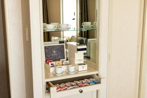 a cabinet with cups and other items on it at Hilton Tokyo Narita Airport in Narita
