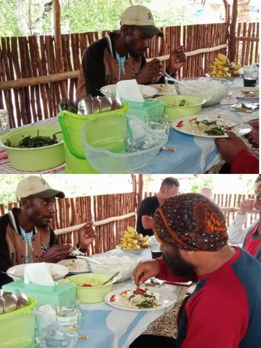 a group of men sitting at a table eating food at manyaifun guest house in Minyaifuin