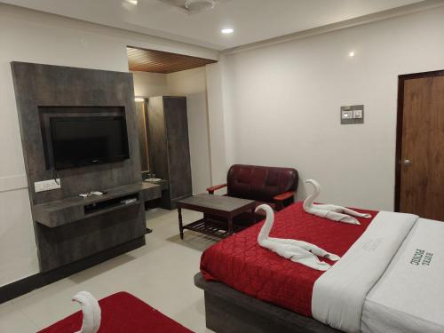 a hotel room with two swans on a bed at Hotel Picnic in Velānganni