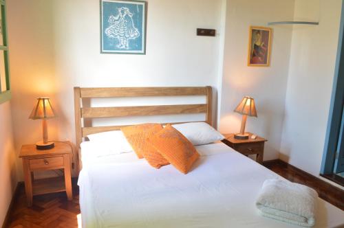 a bedroom with a white bed with two lamps at Pousada Baluarte in Salvador