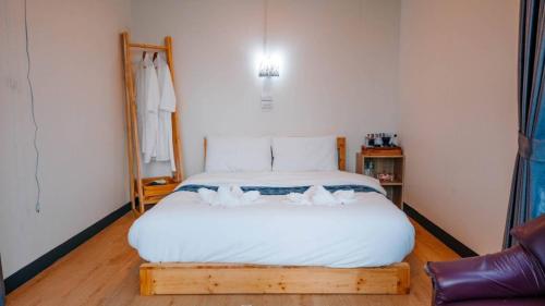 a bedroom with a large bed with white sheets at ภูสิริ โฮมสเตย์ in Ban Thung Phan Ha