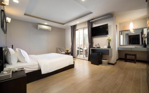una habitación de hotel con una cama y un televisor en F L G Hotel, en Phnom Penh