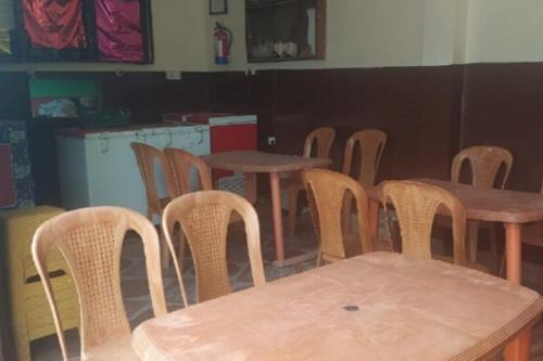 a group of wooden tables and chairs in a room at StayApart - Hari Keshari Home Stay in Gopeshwar