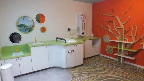 a bathroom with white cabinets and a tree on the wall at Vayamundo Houffalize in Houffalize