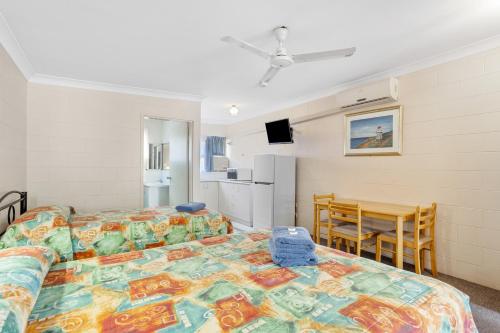 a bedroom with a bed and a table and a dining room at Cooktown Holiday Park in Cooktown