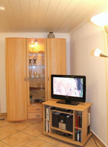 a television sitting on a stand in a room at Kleiner Bungalow in Grömitz