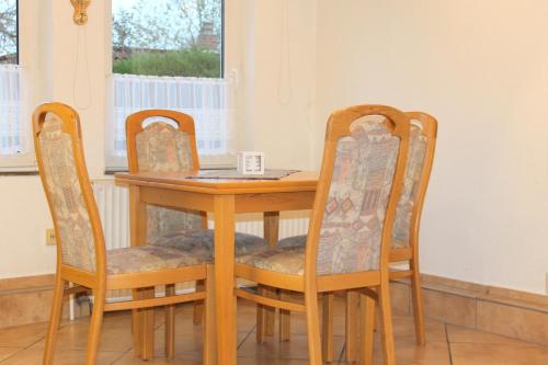 a dining room table with two chairs and a table and a table and chairsktop at Kleiner Bungalow in Grömitz
