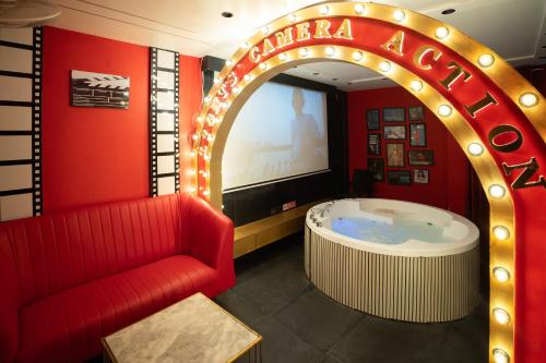 a hot tub in a room with a red wall at Orsom Stays Sassy - Sector 42 in Gurgaon