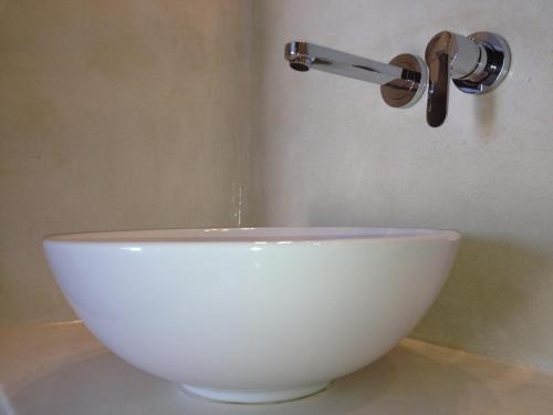a white bowl filled with water next to a white sink at Villa Fotini in Firostefani