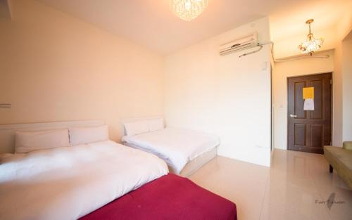two beds in a room with a red rug at 七號會館 in Puli