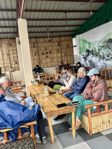 eine Gruppe von Menschen, die an einem Tisch in einem Restaurant sitzen in der Unterkunft GreenDay Escapes Rishikesh in Rishikesh