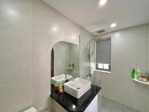 a white bathroom with a sink and a mirror at Biệt thự 4 Phòng Ngủ Novaworld Phan Thiết in Bình Tú