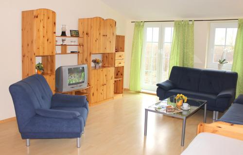 a living room with two blue chairs and a tv at "Hof Triangel - Whg 2" - Bauernhofurlaub in Riepsdorf