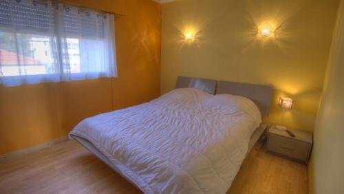 une chambre avec un lit avec des draps blancs et une fenêtre dans l'établissement 3 pièces 4 étoiles Vue Mer Parking Fibre 500m Palais Festivals, à Cannes