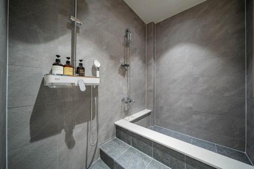 a bathroom with a shower and a bath tub at Hound Hotel DaeGu in Daegu