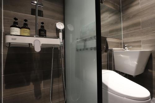 a bathroom with a toilet and a glass door at Hound Hotel DaeGu in Daegu