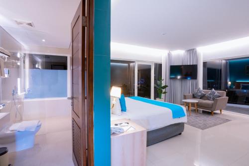 a hotel room with a bed and a bathroom at Zasgo Hotel in Labuan Bajo
