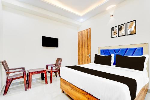 a bedroom with a bed and two chairs at Hotel O Blu Plaza in Gurgaon