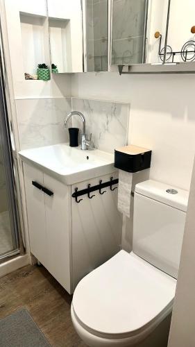 une salle de bain blanche avec des toilettes et un lavabo dans l'établissement FLC -Catalan Beach-Sea View- Clim - Terrace - Parking, à Marseille