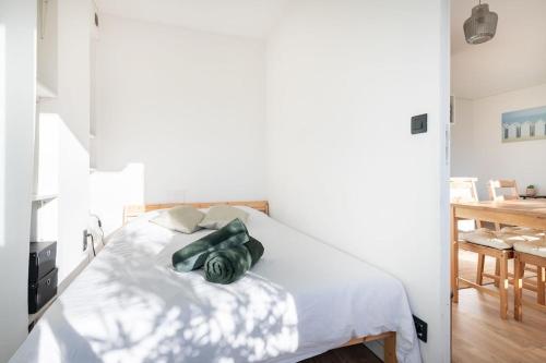 - une chambre avec un lit avec des draps blancs et une table dans l'établissement FLC -Catalan Beach-Sea View- Clim - Terrace - Parking, à Marseille