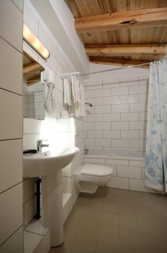 a white bathroom with a sink and a toilet at Chalet Hotel La Tarine in Peisey-Nancroix