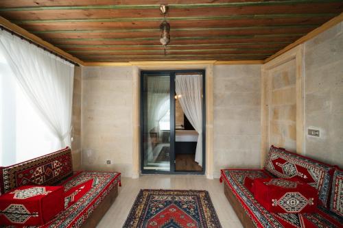 a room with two red couches and a window at İncebey Konak Cappadocia in Uçhisar
