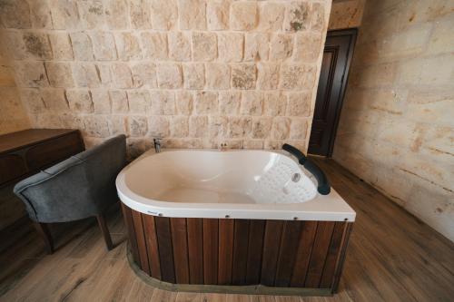 a bath tub in a room with a brick wall at İncebey Konak Cappadocia in Uçhisar