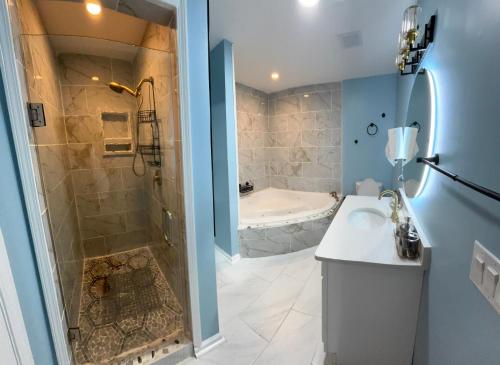 a bathroom with a shower and a sink and a tub at CeloVacationHousing in Memphis