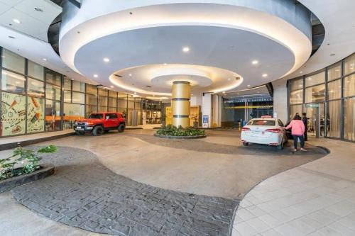 un grand bâtiment avec des voitures garées dans un parking dans l'établissement Horizons 101 Condotel, à Cebu