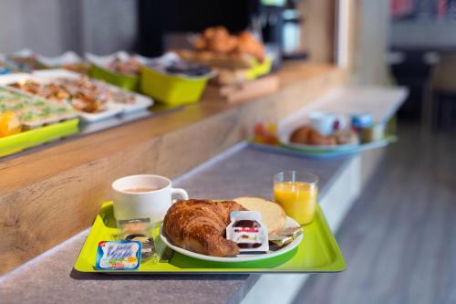 a tray with a plate of food and a cup of coffee at Hotel Ibis Budget Nancy Centre in Nancy