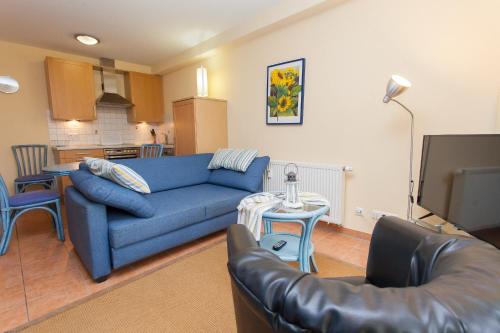 ein Wohnzimmer mit einer blauen Couch und einem Fernseher in der Unterkunft Birkenstraße 7 Whg 2 in Zingst