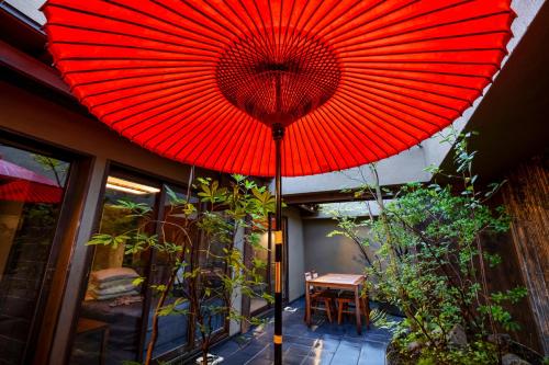 a red umbrella on top of a patio at GOZAN HOTEL & SERVICED APARTMENT Higashiyama Sanjo in Kyoto