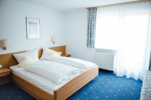 Un pat sau paturi într-o cameră la Hotel Garni Noval