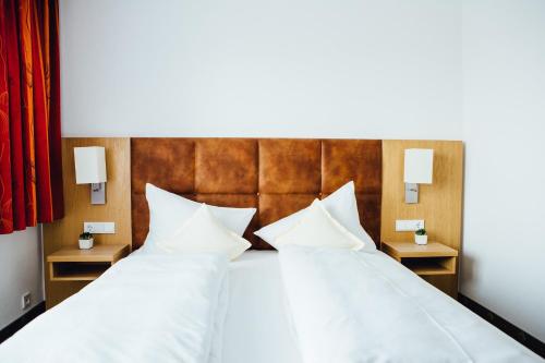 سرير أو أسرّة في غرفة في Hotel Garni Noval