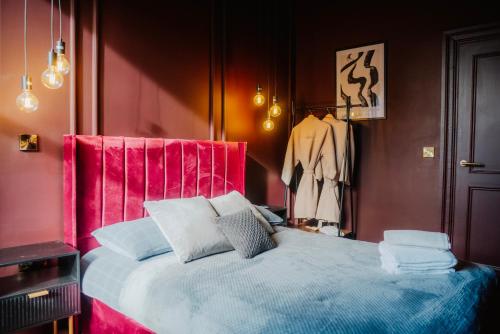 a bedroom with a bed with a red head board at Stunning Town Centre Apartments with Spa facilities in Morpeth