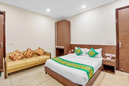 a bedroom with a bed and a couch at Treebo Elegant Palace in New Delhi