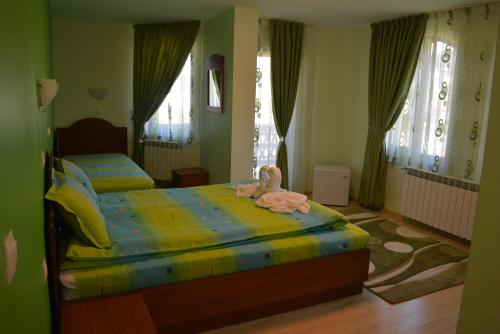 ein Schlafzimmer mit 2 Betten und einem ausgestopften Tier auf dem Bett in der Unterkunft Guest House H Dzhogolanov in Kopriwschtiza