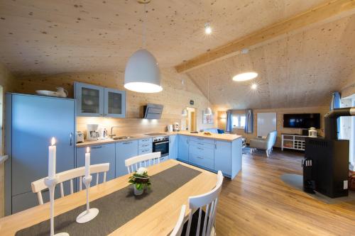 a kitchen with blue cabinets and a table and chairs at Typ A plus "Schoner" -Skipperhaus- in Pelzerhaken