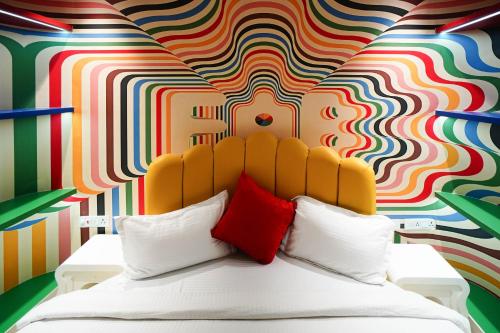 a bedroom with a bed with a colorful wall at Orsom Stays Sassy - Sector 42 in Gurgaon