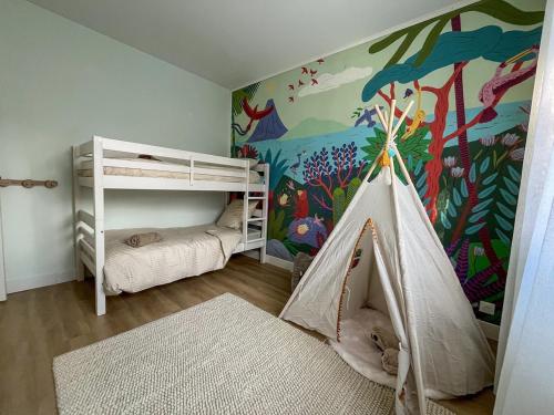 une chambre d'enfant avec deux lits superposés et une fresque murale dans l'établissement Villa de charme à 100 m de la mer, à Saint-Palais-sur-Mer