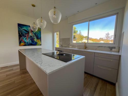 une cuisine avec un comptoir et une grande fenêtre dans l'établissement Villa de charme à 100 m de la mer, à Saint-Palais-sur-Mer