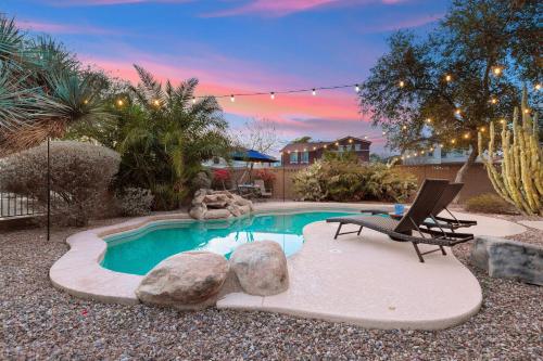 a swimming pool in a yard with a bench and a chair at Goodyear Springs in Goodyear