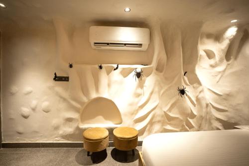 a bathroom with a toilet and two stools at Orsom Stays Sassy - Sector 42 in Gurgaon