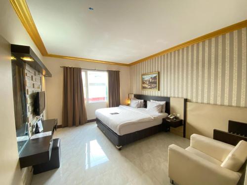 ジェンベルにあるHotel 88 Jember By WH - Strategic Location In The City Centerのベッドとソファのあるホテルの部屋
