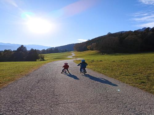 two children riding bikes down a gravel road at Apartment in Stans near Wolfsklamm River in Stans